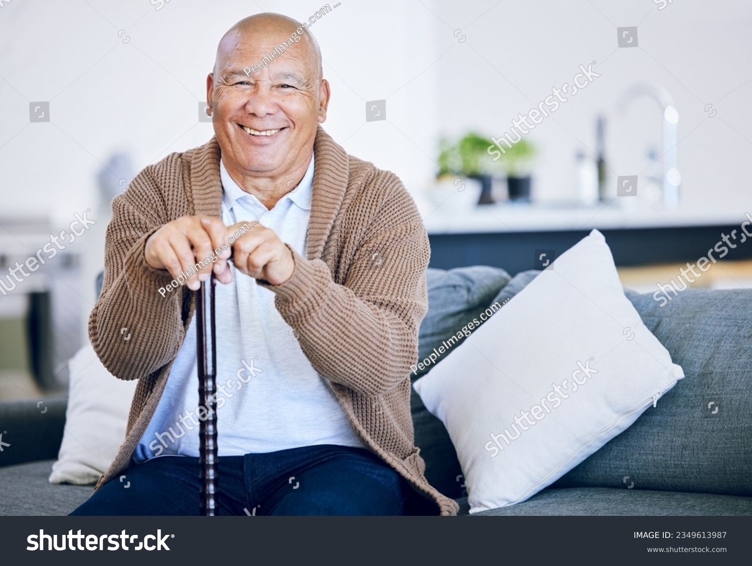 Portrait, home and old man with a smile, walking stick and relax with retirement, peace and calm on a couch. Senior person in a living room, elder or pensioner on a sofa, cane or support with health #2349613987