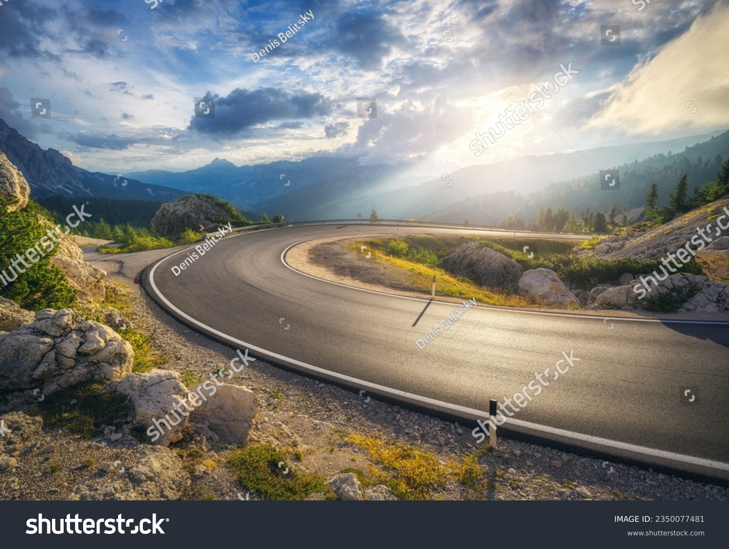 Mountain road at colorful sunset in summer. Dolomites, Italy. Beautiful curved roadway, rocks, stones, blue sky with clouds. Landscape with empty highway through the mountain pass in spring. Travel #2350077481