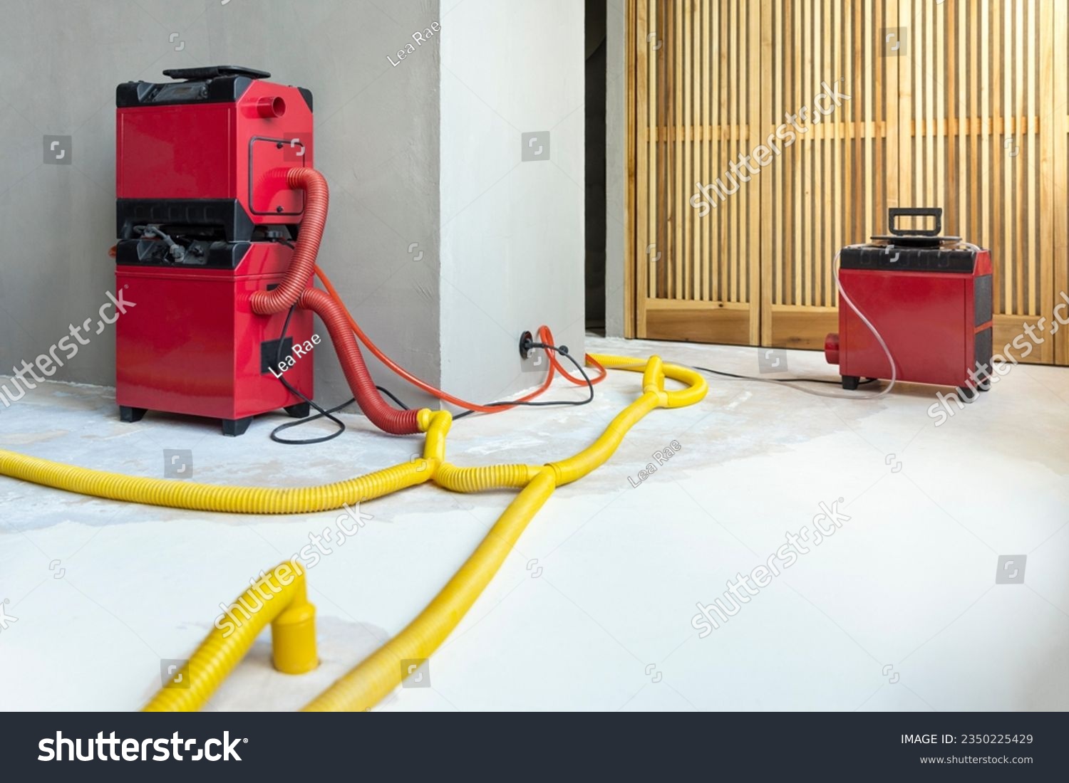 Water damage restoration service for a leaking home environment with industrial air movers, dehumidifiers and pipes to remove water and moist from the wet floor. Repair the house. Household insurance #2350225429