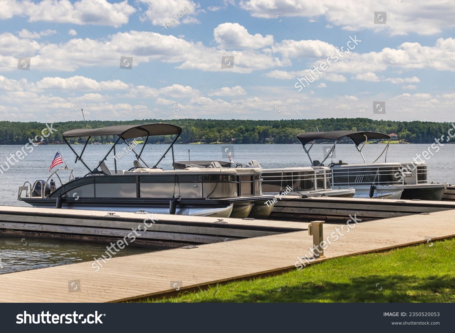 Multiple pontoon boats at marina dock on freshwater lake. #2350520053