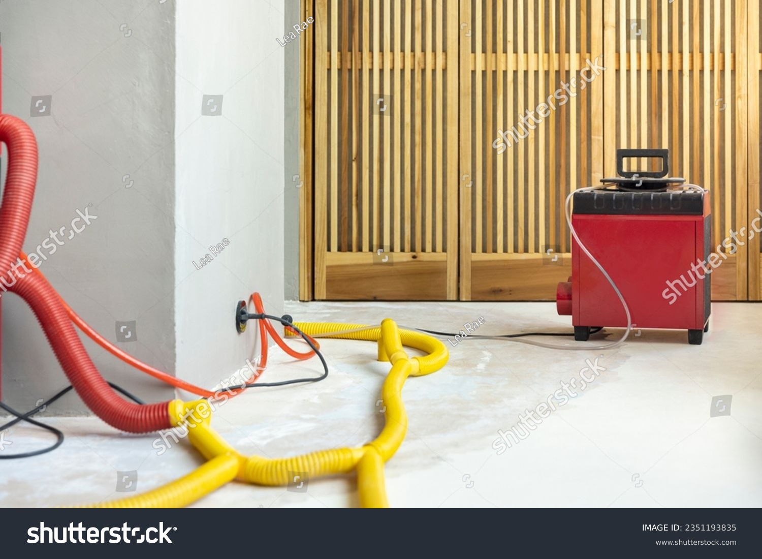 Water damage restoration service in a leaking home with industrial air movers, dehumidifiers and pipes to remove the water and moist from the wet floor and repair the house. Household insurance #2351193835