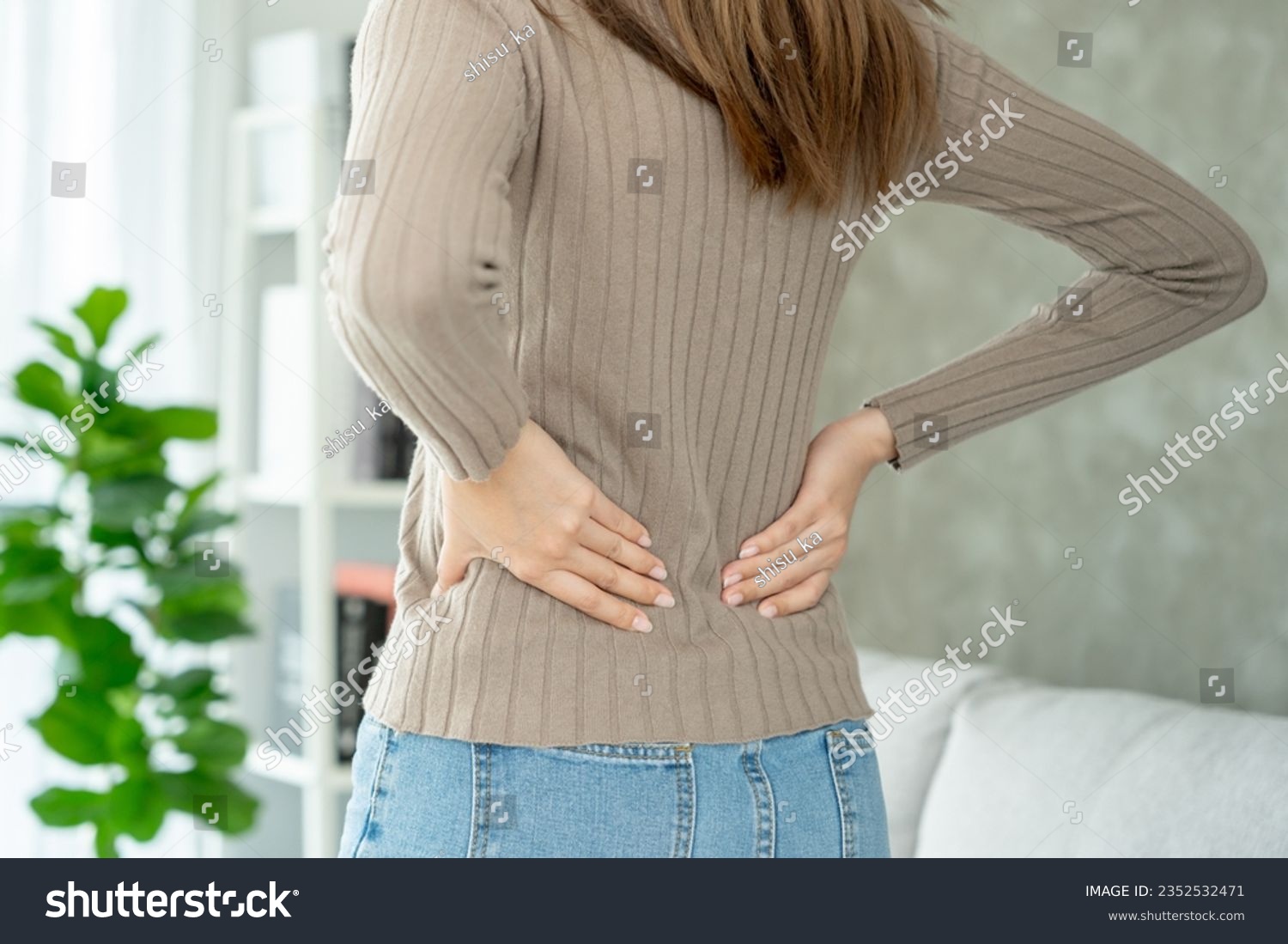 Asia beautiful woman holding her lower back while and suffer from unbearable pain health and problems, chronic back pain, backache in office syndrome, scoliosis, herniated disc, muscle inflammation #2352532471