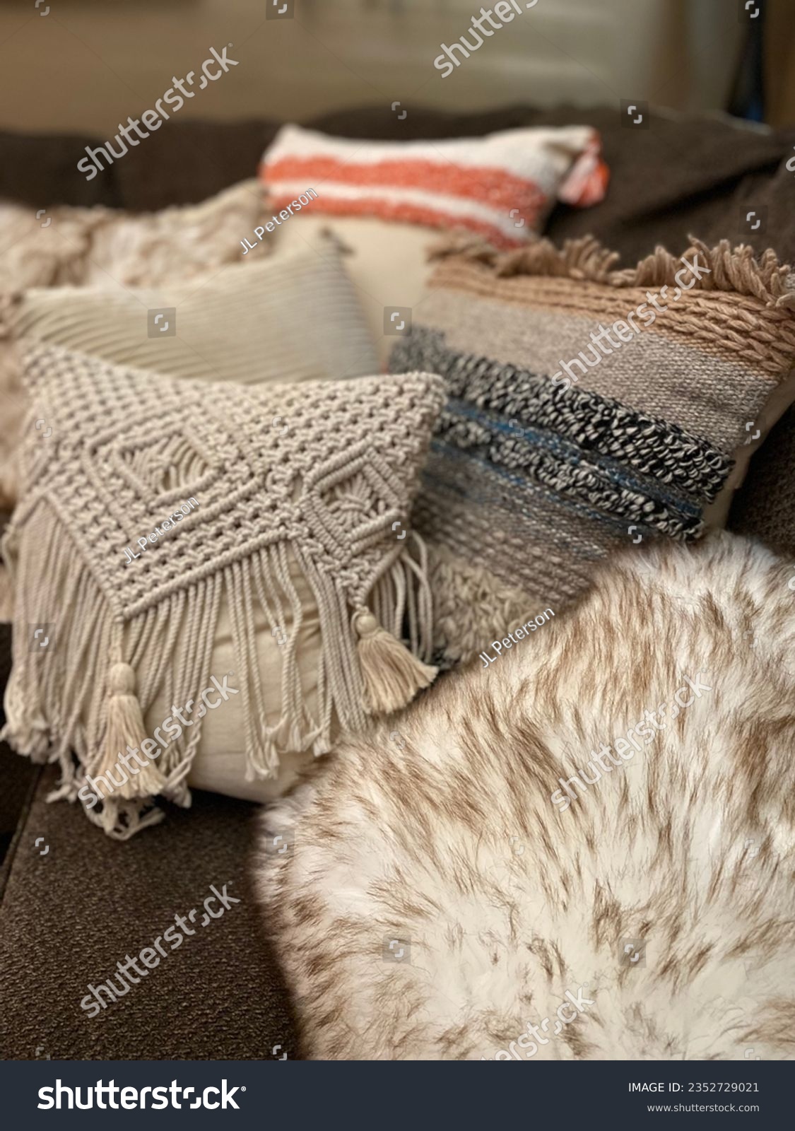 Cozy sofa corner with trendy textured boho toss pillows #2352729021