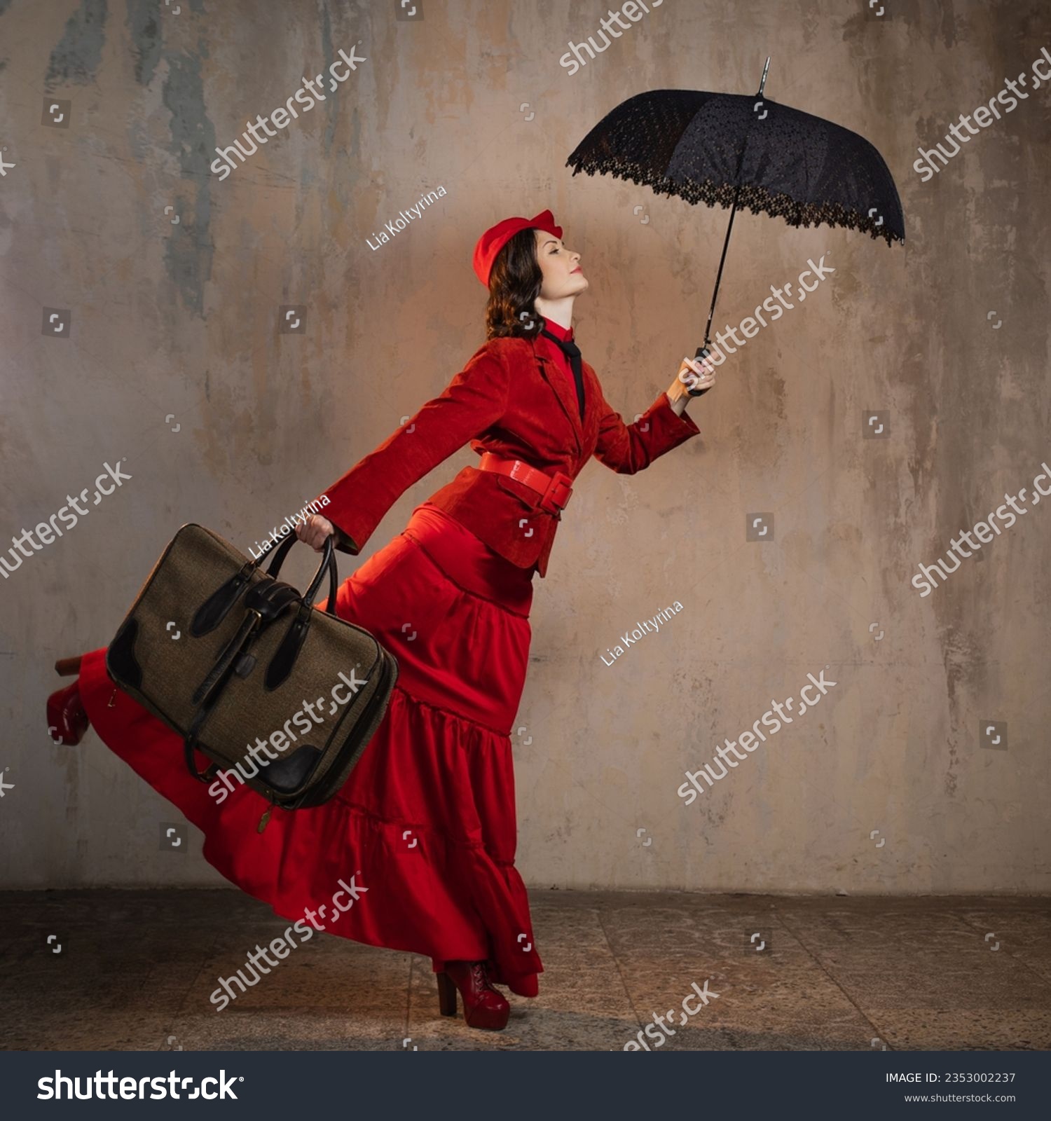A stylish lady in a red old-fashioned suit with a hat and a lace umbrella #2353002237