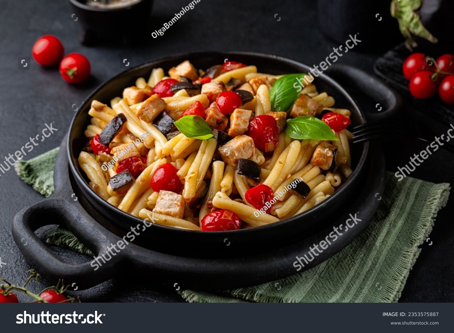 Sicilian pasta, casarecce with swordfish, tomato, and eggplant. Decorated with basil leaves. Dark table surface. #2353575887