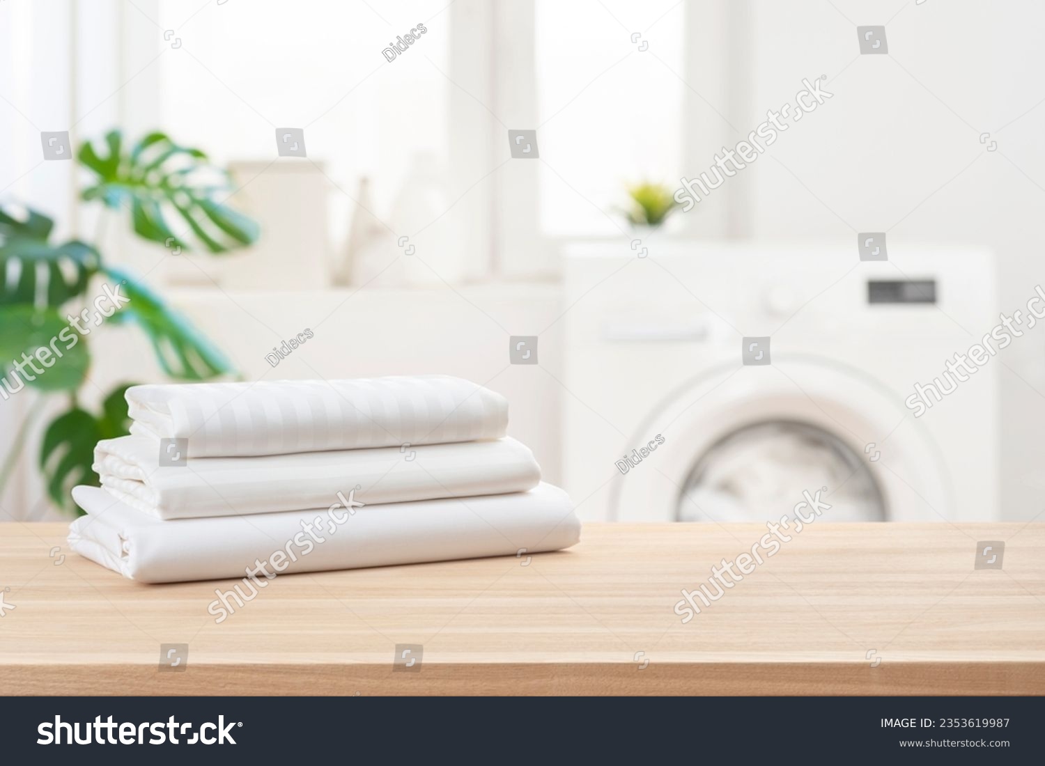 Stack of clean laundry bedding sheets on table in bathroom #2353619987