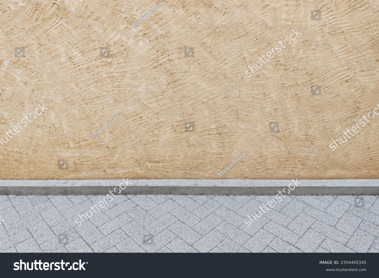 Textured background of a light beige or cream painted concrete wall on a street with a view of part of the road #2354445345