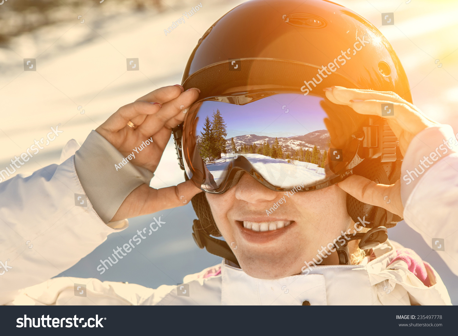 Woman wearing a helmet and glasses on the background of snow winter and mounts.  #235497778