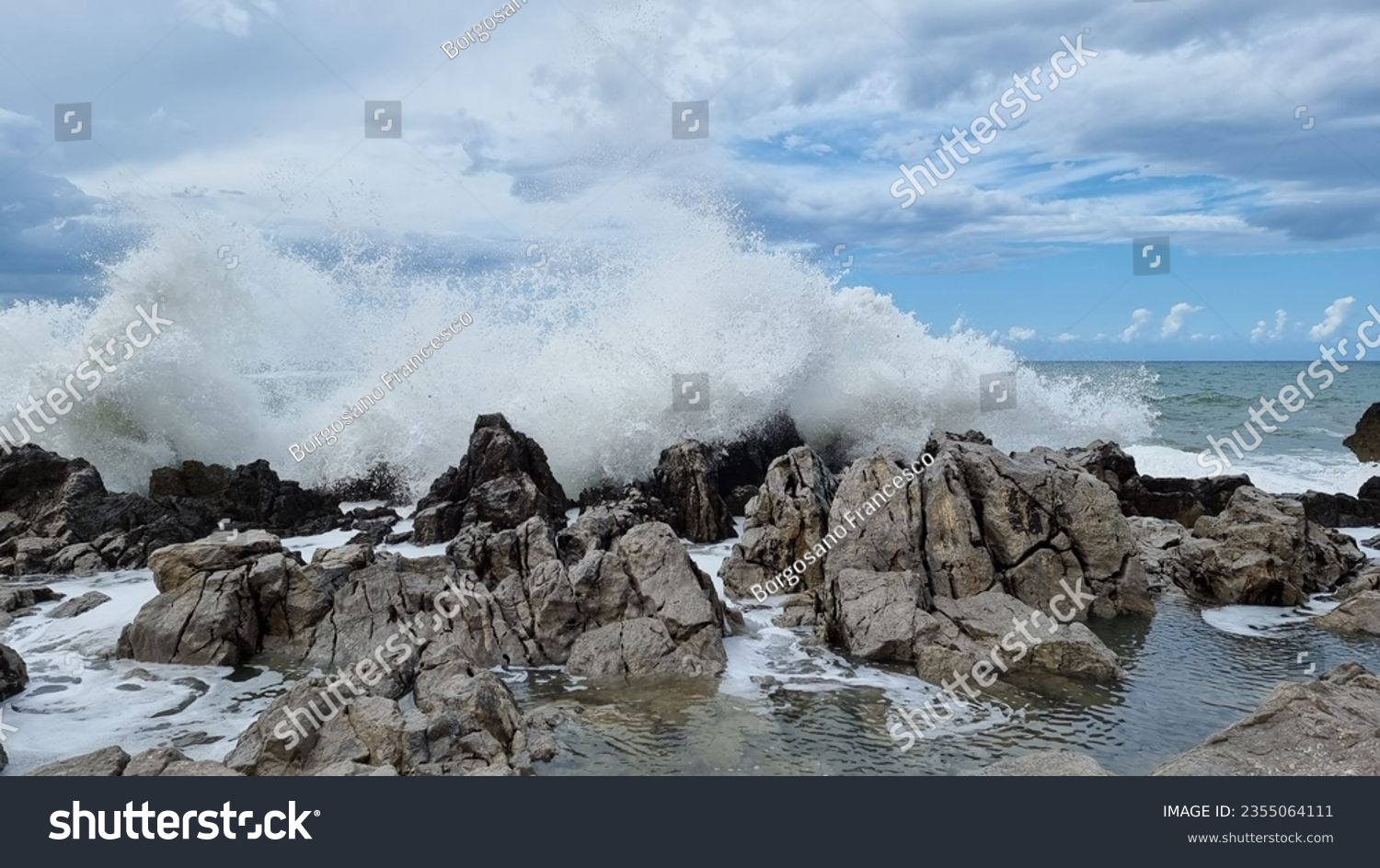 Sea surf that expands in the air during. Sea driven by the fresh Mistral wind. Freedom of nature. Ancient rocks that on the coast embrace the impetuous sea that breaks furiously #2355064111