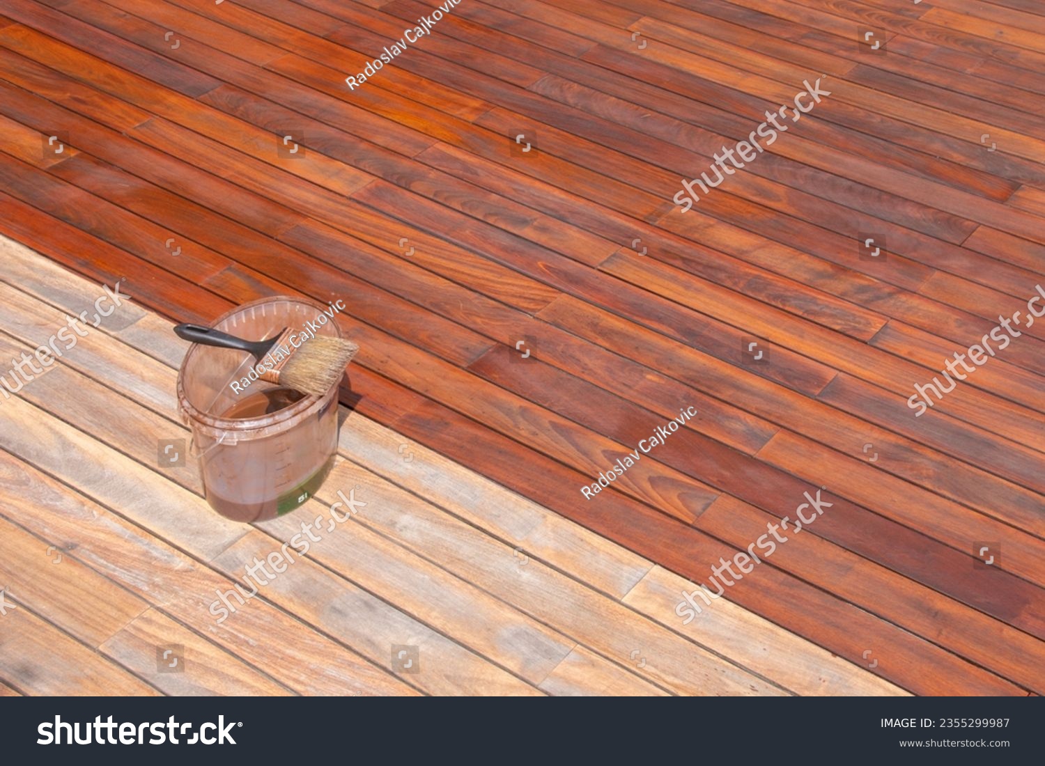 Wood deck oil and paint brush on the bucket, exterior terrace renovation treatment and maintenance #2355299987