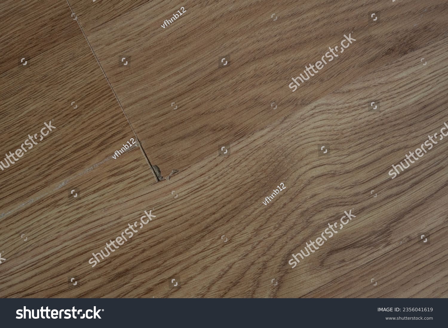 Laminate flooring with visible defects like chips, cracks, and unevenness. #2356041619