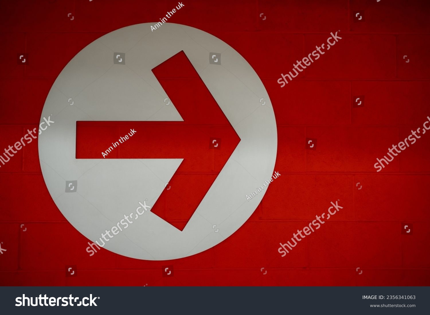Arrow sign in white circle on red brick wall background, Directional Arrow  pointing to right side #2356341063