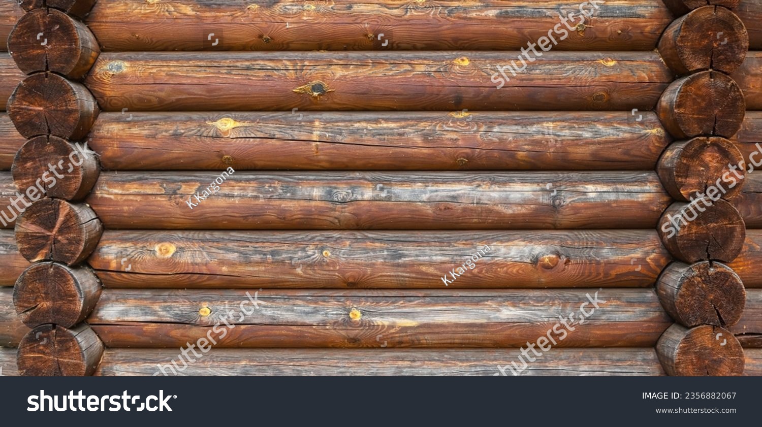 A log wall construction with a swedish cope log profile. Dirty and heavily cracked brown wall of a blockhouse as a natural rural background #2356882067