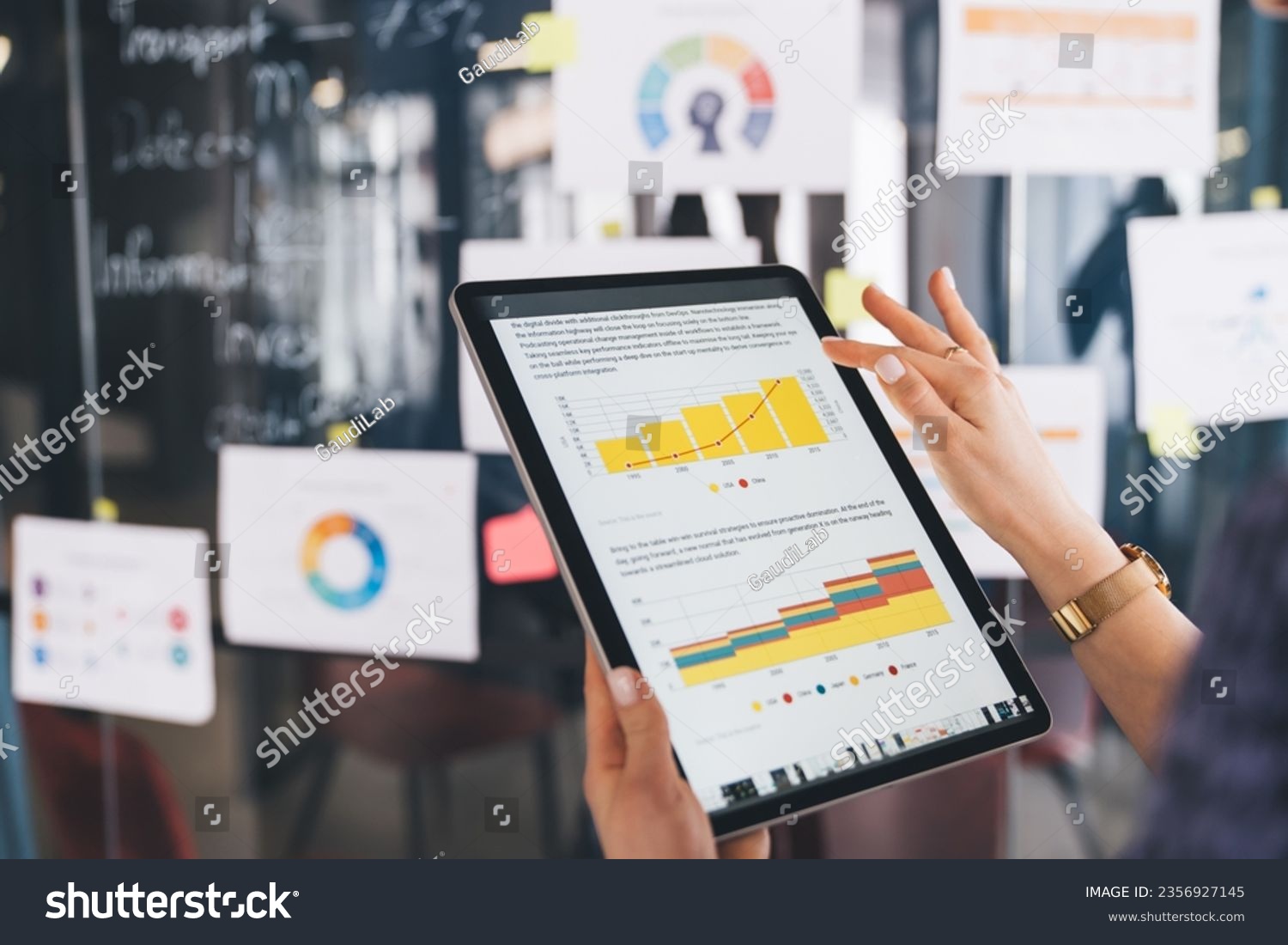 Unrecognizable female marketer checking financial report with infographics while browsing web document on modern touch pad, cropped entrepreneur with digital tablet reading business information #2356927145