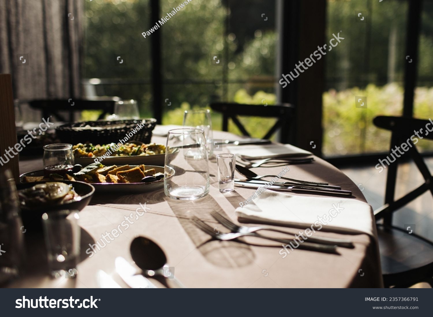 Luxurious Restaurant Table with shiny cutlery. Opulent Setting for Fine Dining Experience. High end restaurant. Romantic dinner in sunset light. Sunlight table. Vodka shot glass. #2357366791