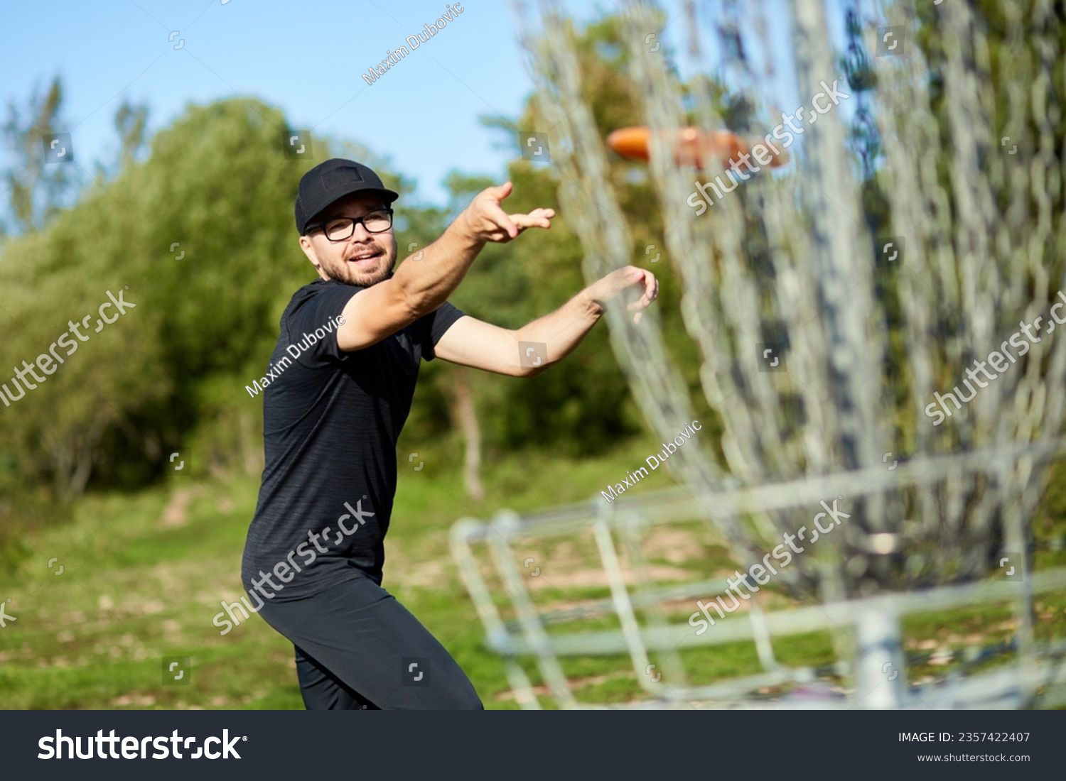 Man is throwing disc to the basket in disc golf #2357422407
