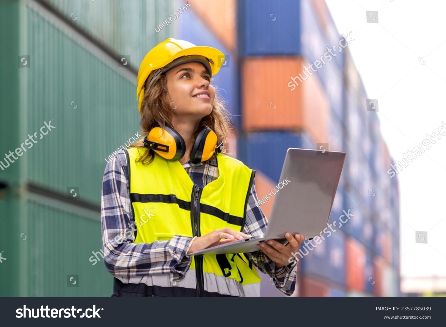 Portrait of caucasian female engineer in container yard, International import export and logistic business concept. Logistics, transportation, distribution concept. Factory, warehouse, worker. #2357785039