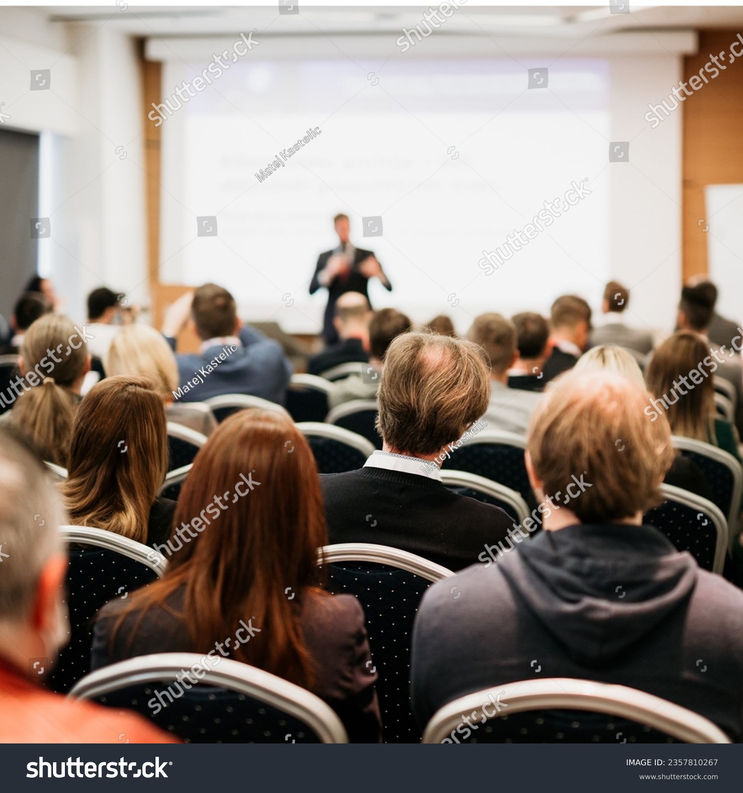 Speaker giving a talk in conference hall at business event. Rear view of unrecognizable people in audience at the conference hall. Business and entrepreneurship concept #2357810267