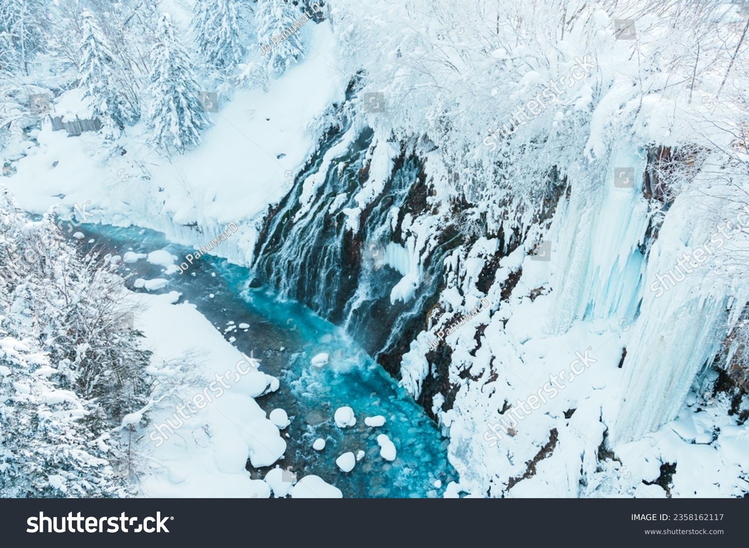 Shirahige Waterfall with Snow in winter, Biei river flow into Blue Pond. landmark and popular for attractions in Hokkaido, Japan. Travel and Vacation concept #2358162117