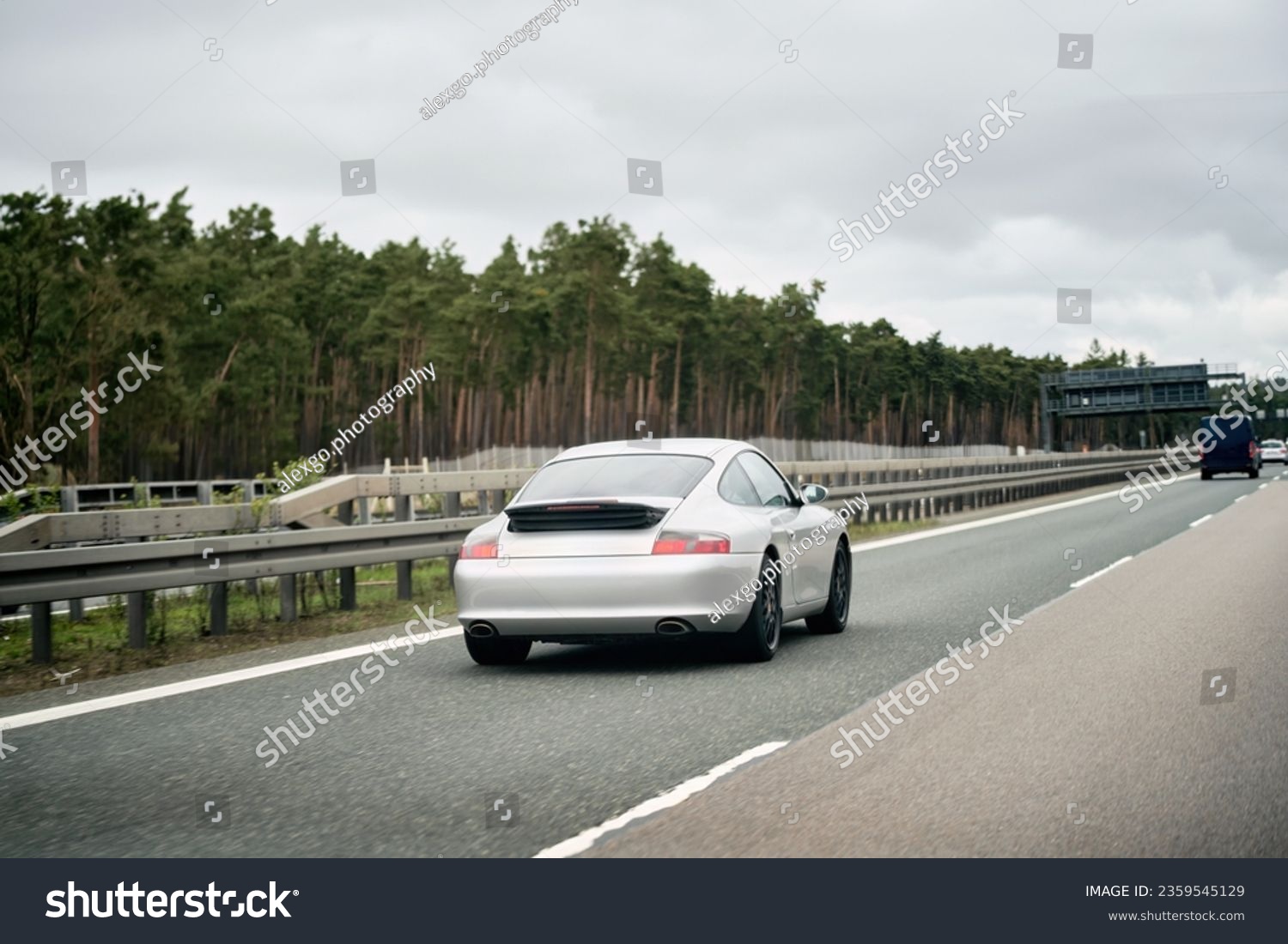 Exquisite Speed and Style on the Highway. Modern European Sportcar. Silver German roadster vehicle on the highway. Silver sport coupe. The expensive sports car on public roads. Autobahn speeding #2359545129