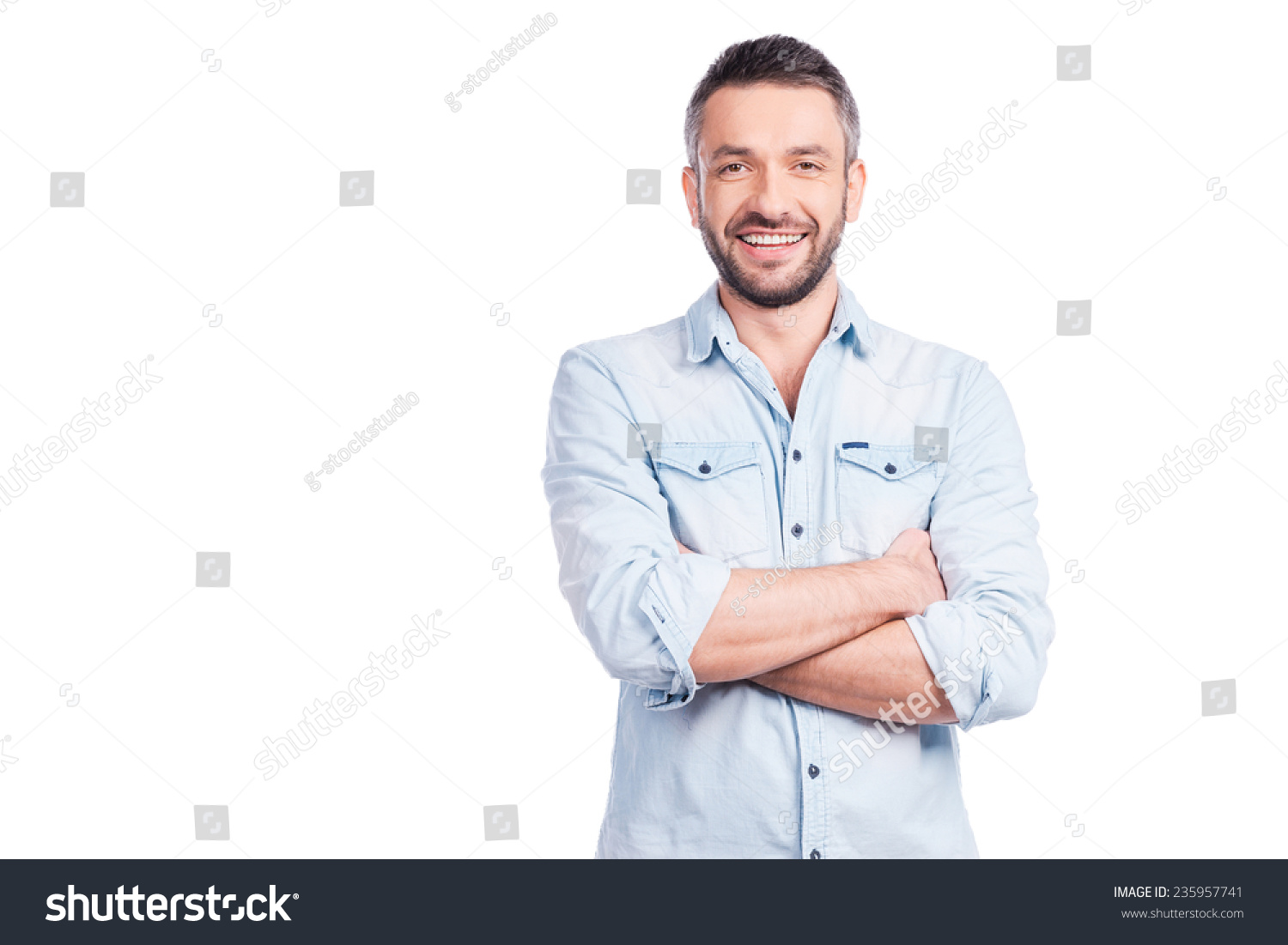 Charming handsome. Handsome young man in casual wear keeping arms crossed and smiling while standing isolated on white background #235957741