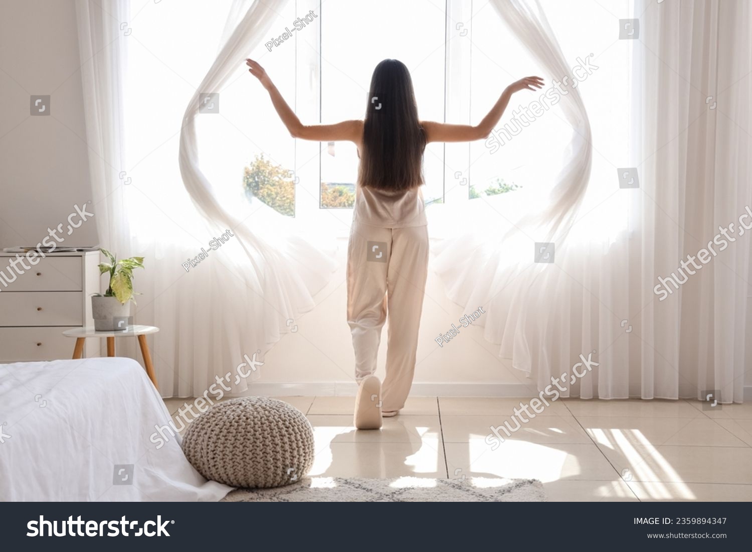 Morning of pretty young woman opening curtains in bedroom #2359894347