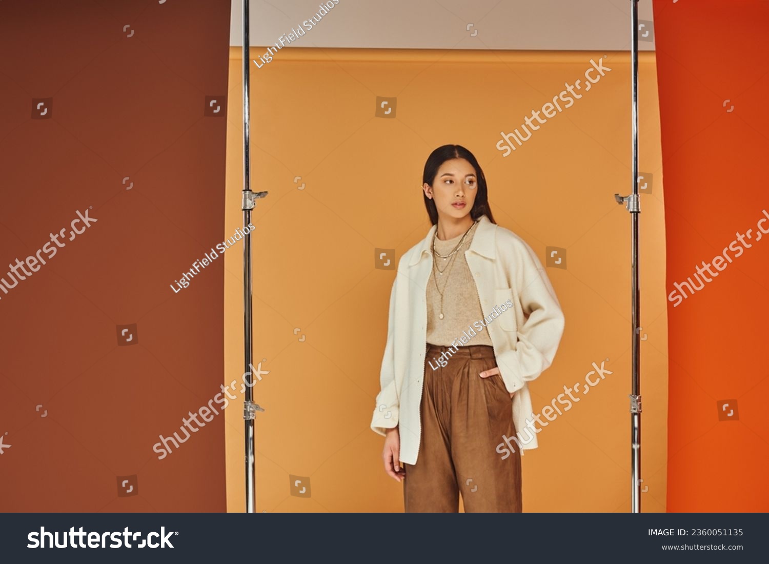 pretty asian woman in autumn outfit posing with hand in pocket, leather pants and outerwear #2360051135