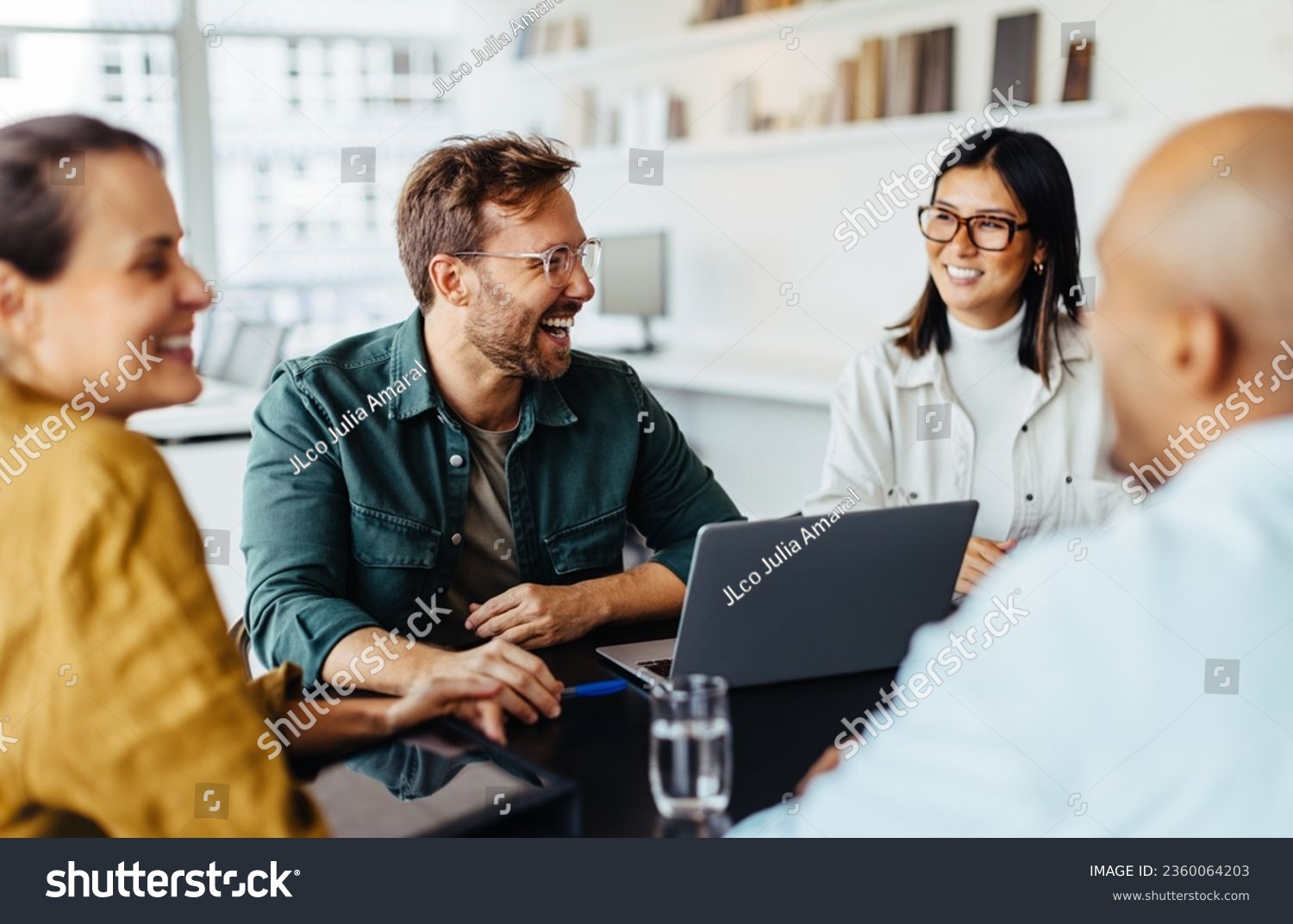 Diverse business people having a team meeting in an office. Group of happy business professionals sitting around a table and having a discussion. #2360064203