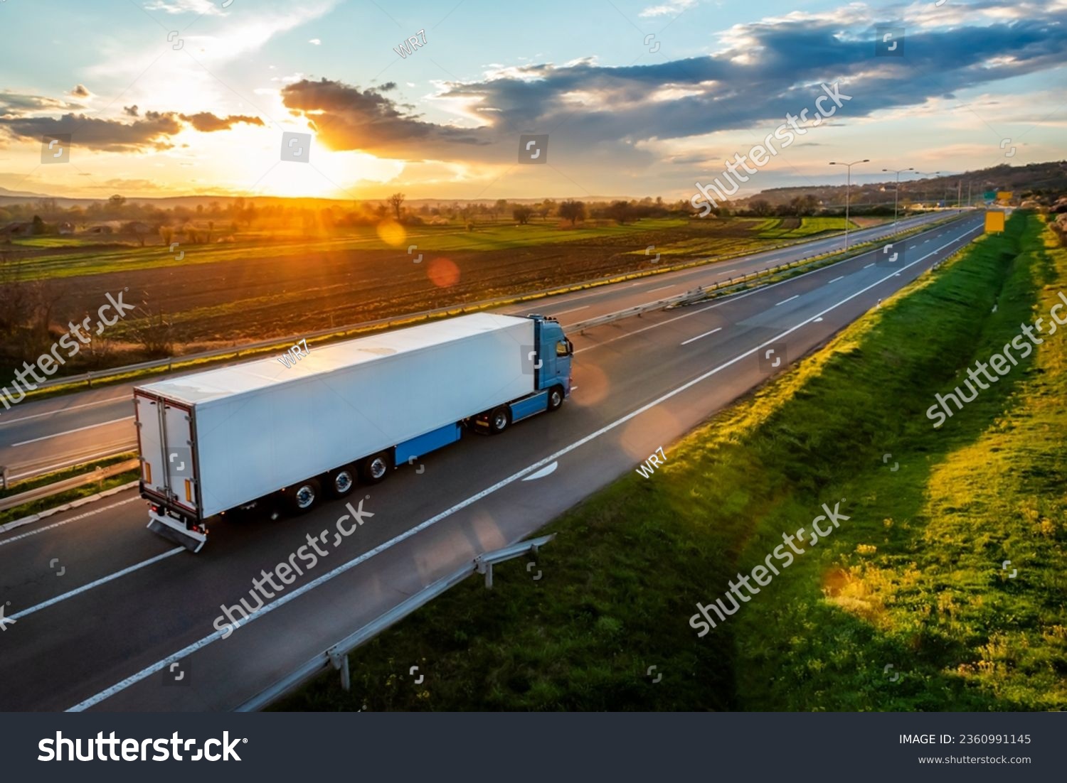 Large Transportation Truck on a highway road through the countryside in a beautiful sunset #2360991145