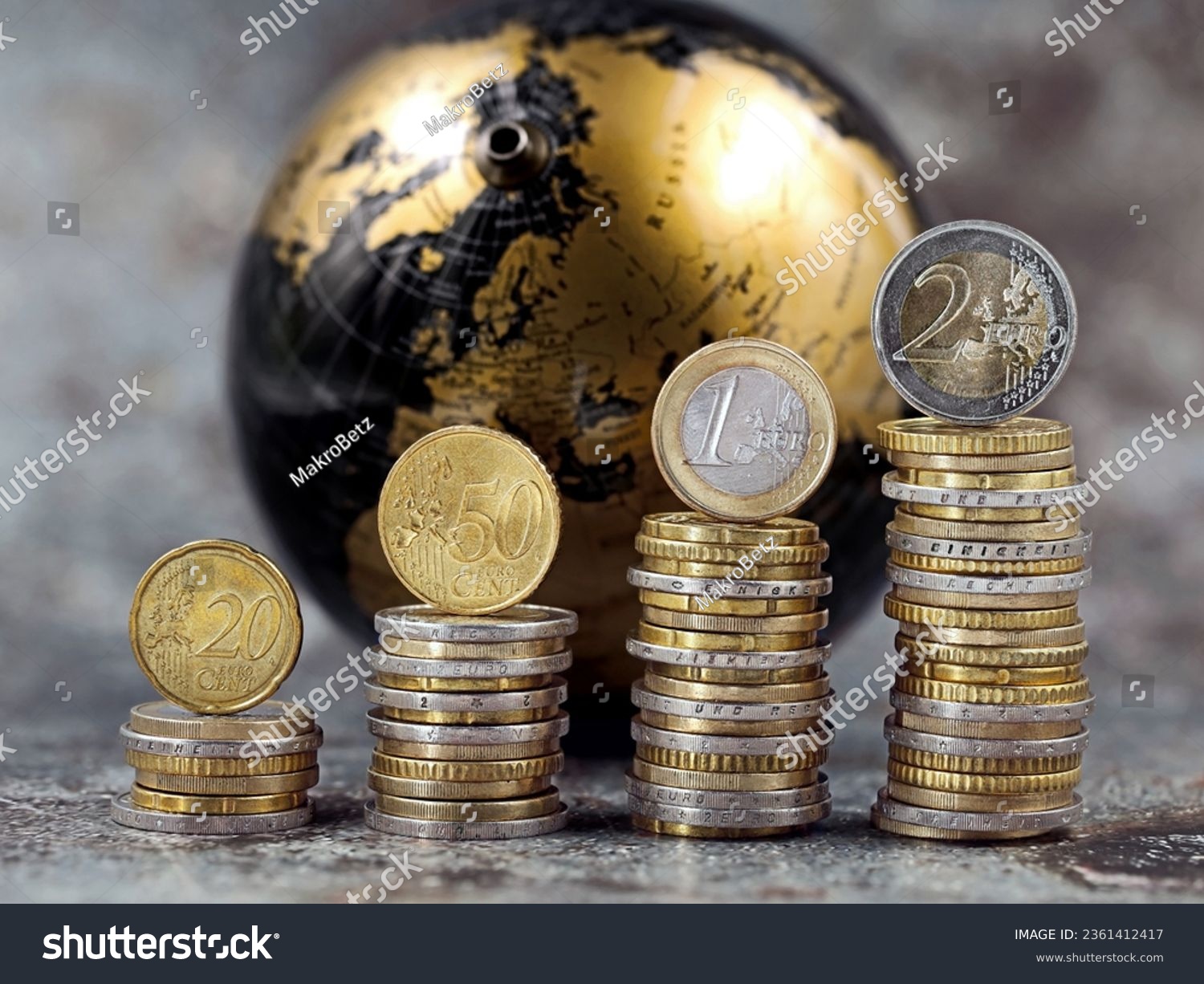stacks of euro and cent coins symbolize a price increase in front of a black and gold globe, concept of money increase, international inflation or global stock trading #2361412417