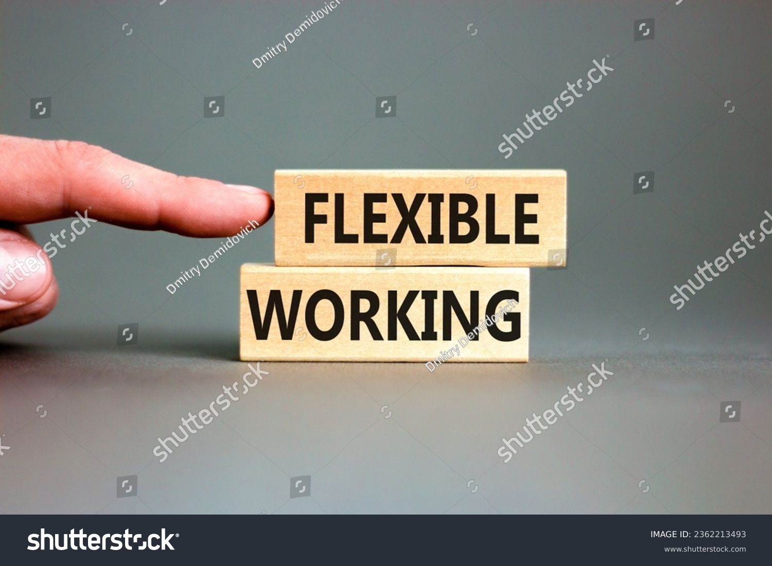 Flexible working symbol. Concept words Flexible working on beautiful wooden blocks. Beautiful grey table grey background. Businessman hand. Business flexible working concept. Copy space. #2362213493