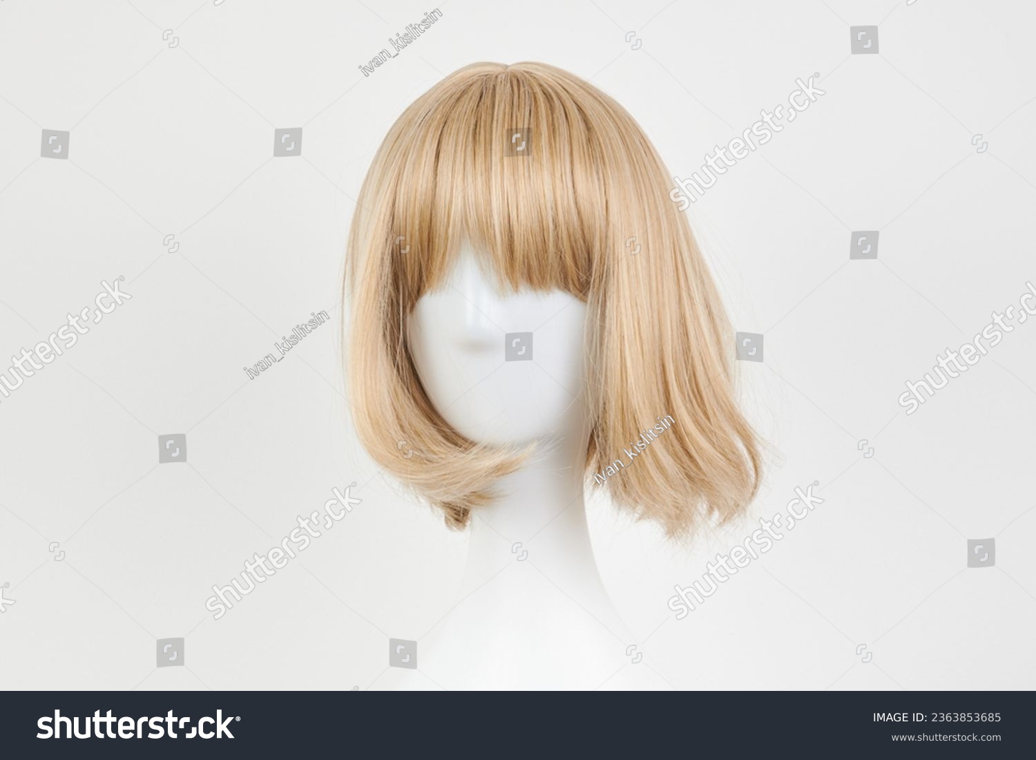Natural looking blonde fair wig on white mannequin head. Short hair cut on the plastic wig holder isolated on white background, front view
 #2363853685