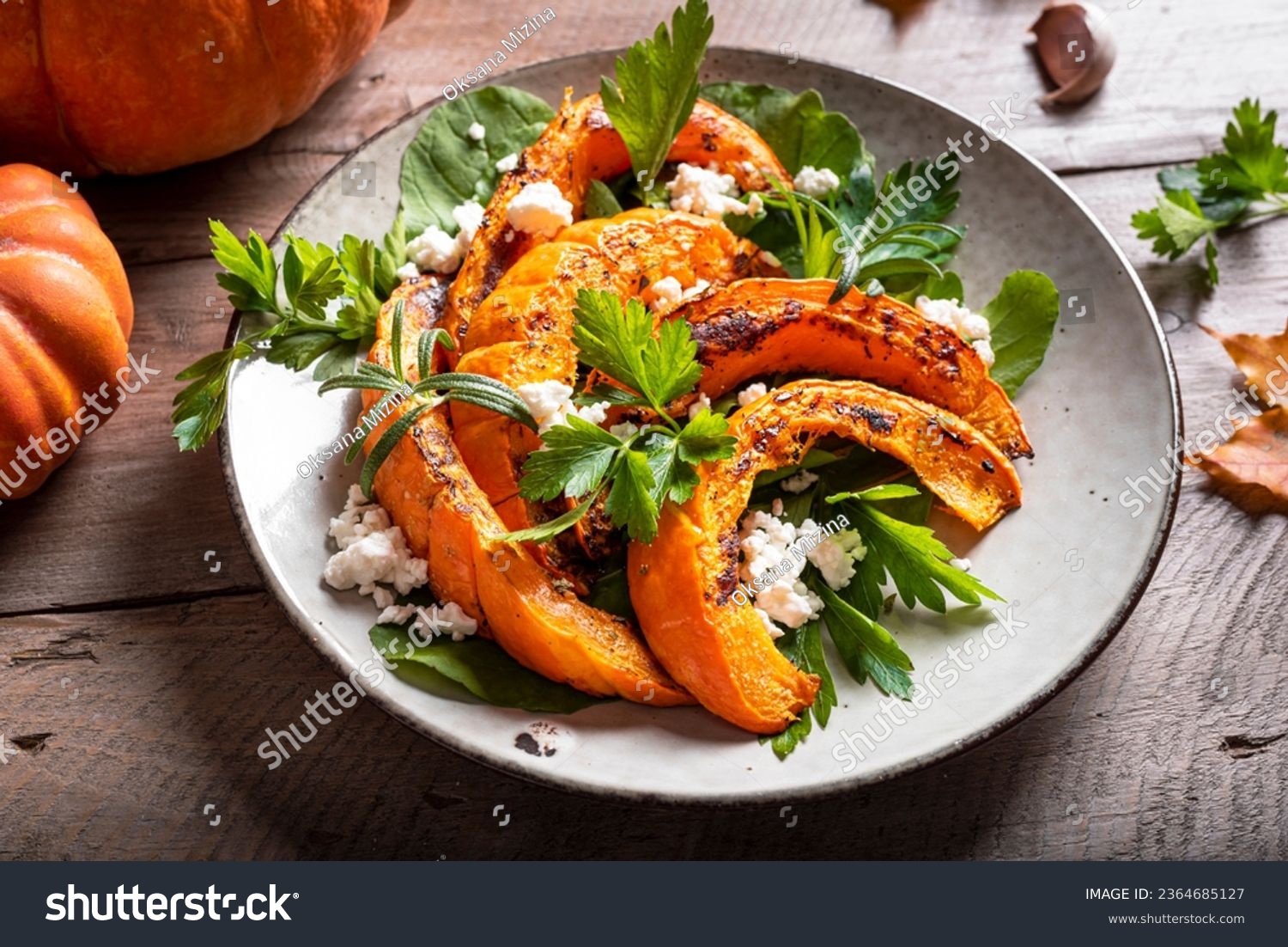 Autumn salad with grilled pumpkin, goat cheese and herbs close up. Seasonal autumn warm salad recipe, vegetarian food. #2364685127