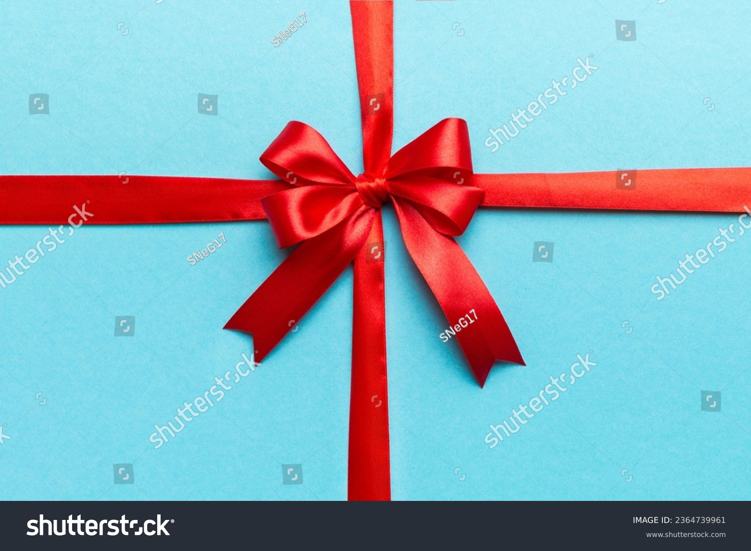 Top view of Red ribbon rolled and red bow isolated on colored background. Flat lay with copy space. #2364739961