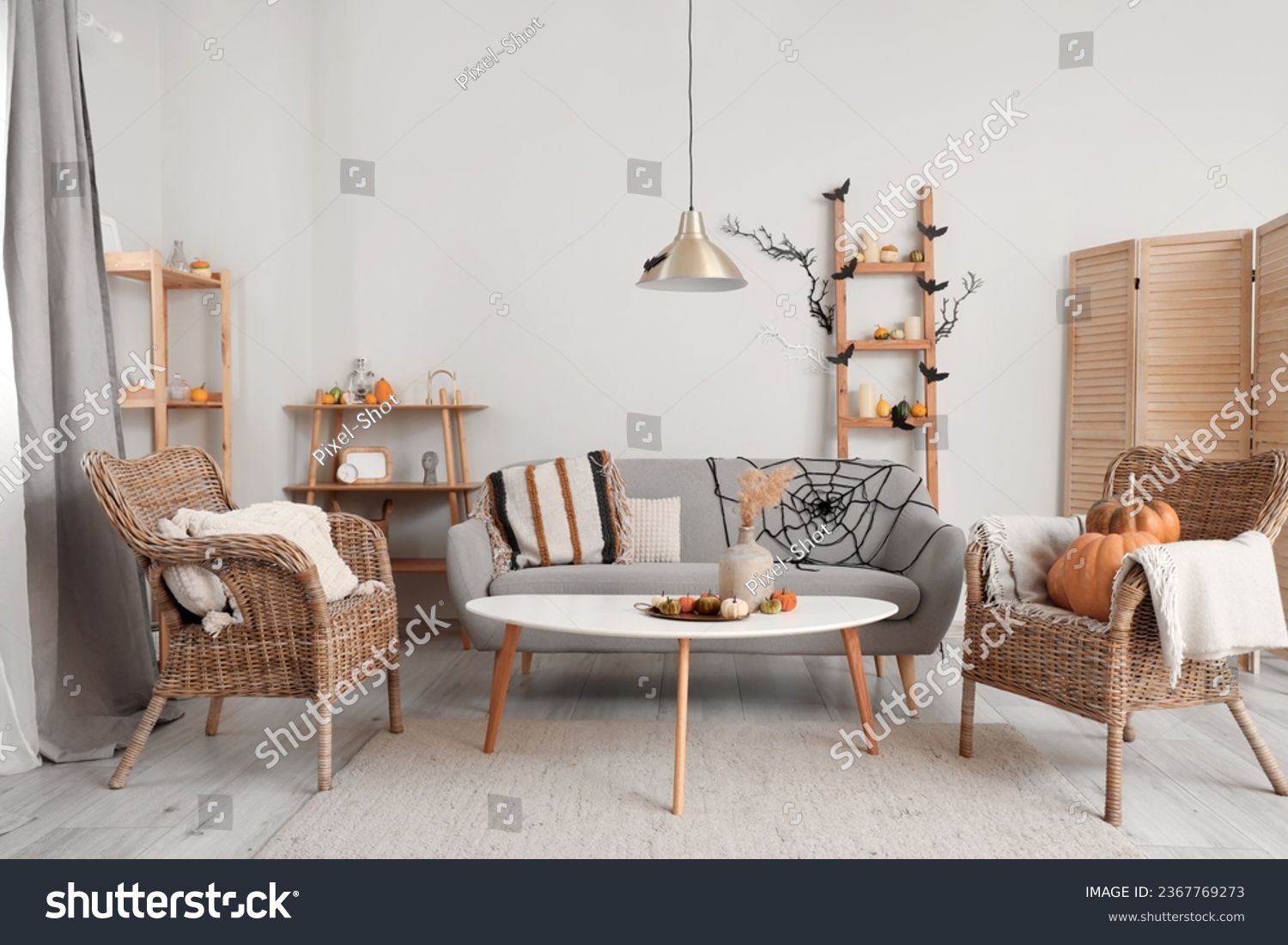 Interior of light living room decorated for Halloween with sofa and armchairs #2367769273