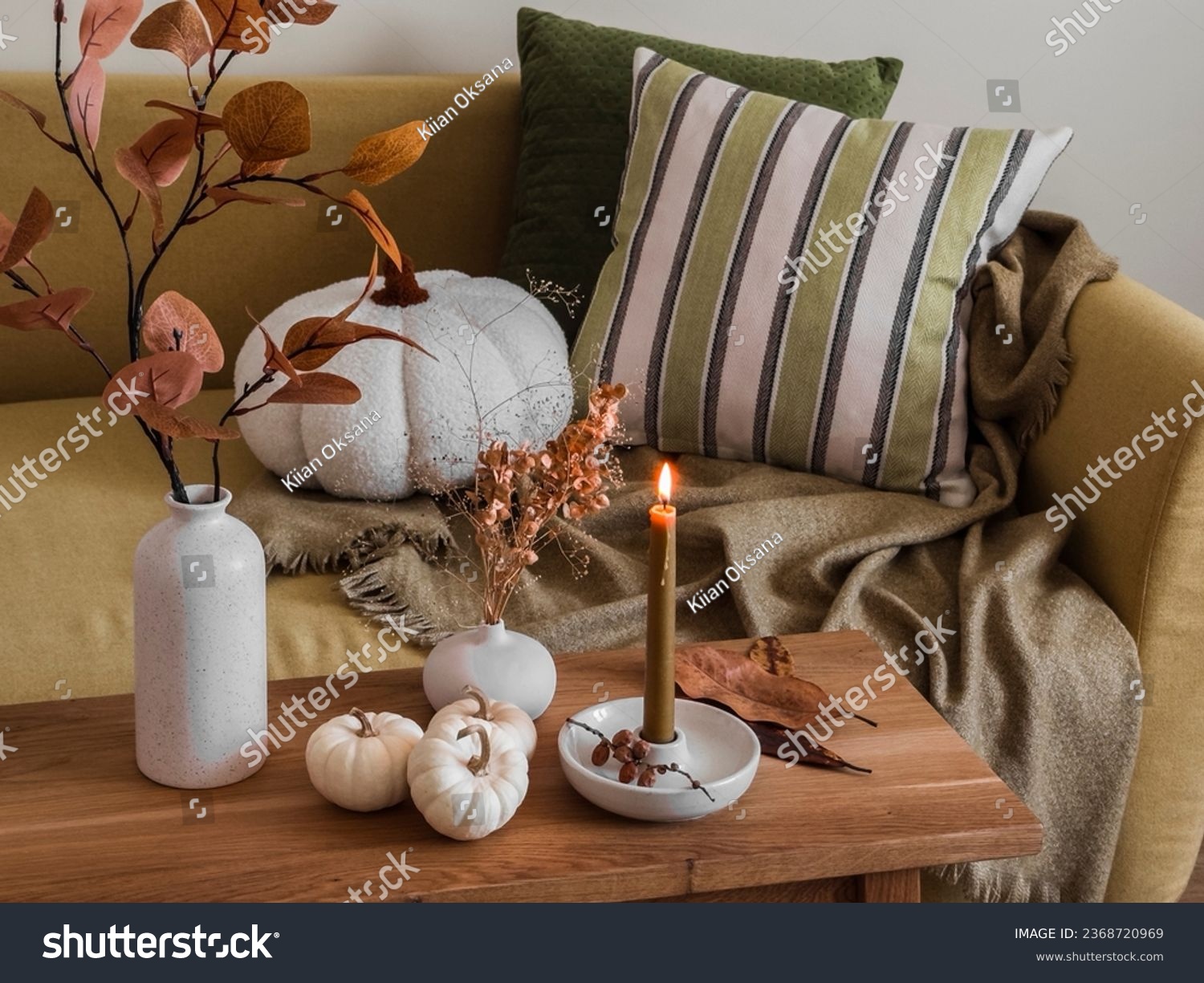 Autumn interior of the living room - sofa with pillows and blankets, wooden bench with autumn decor   #2368720969