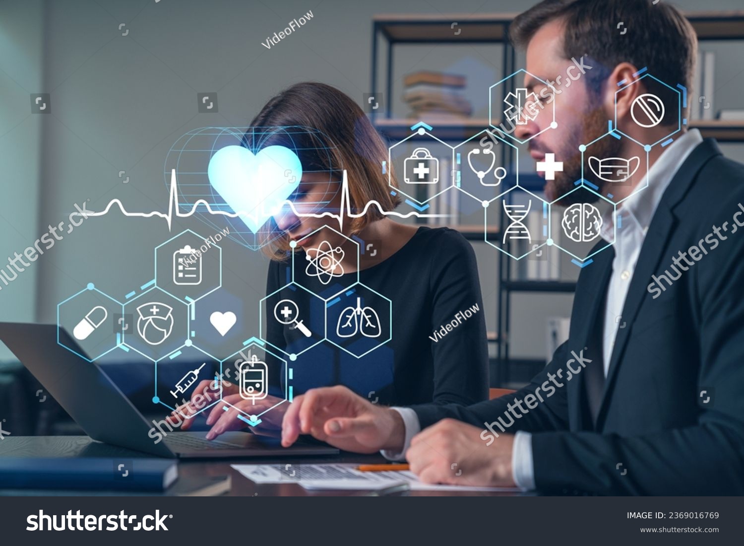 Thoughtful businesspeople typing on laptop at office workplace. Concept of team work, business education, internet surfing, brainstorm, project information technology. Medical healthcare hologram #2369016769