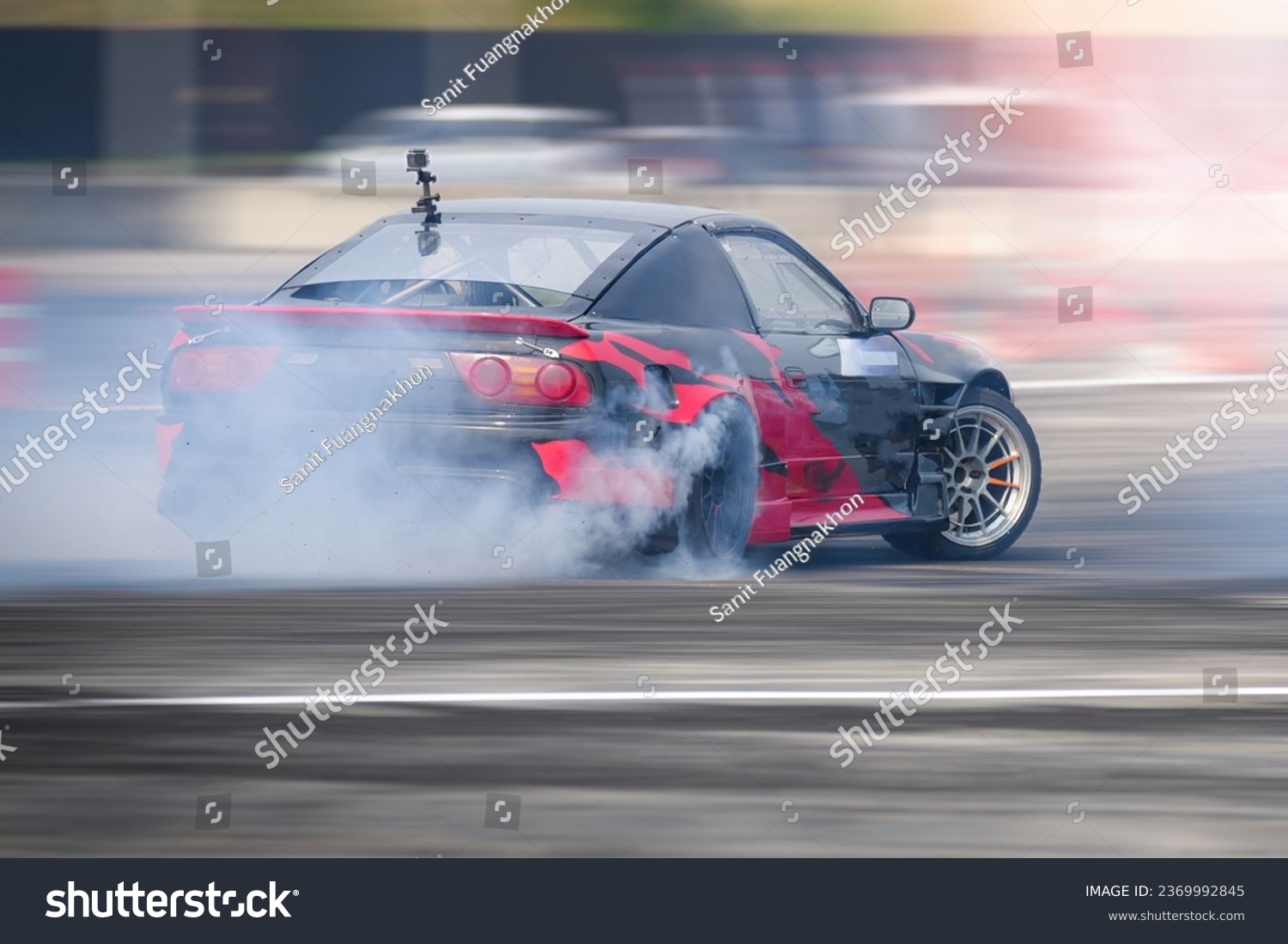 Drifting Sports sedan with modified engine and suspension action car slide faster on asphalt track speed motion blurred  with wheel tire  turning slip burn rubber smoke, Drift motor sport car racing . #2369992845