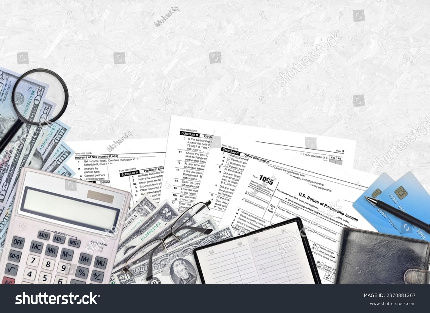 IRS form 1065 U.S. Return of partnership income lies on flat lay office table and ready to fill. U.S. Internal revenue services paperwork concept. Time to pay taxes in United States. Top view #2370881267