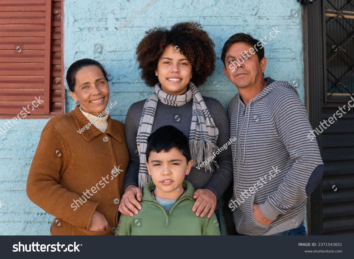 Portrait of latin multigenerational family standing and looking at camera outside the house. Affectionate, bonding, love, generation concept. #2371543651