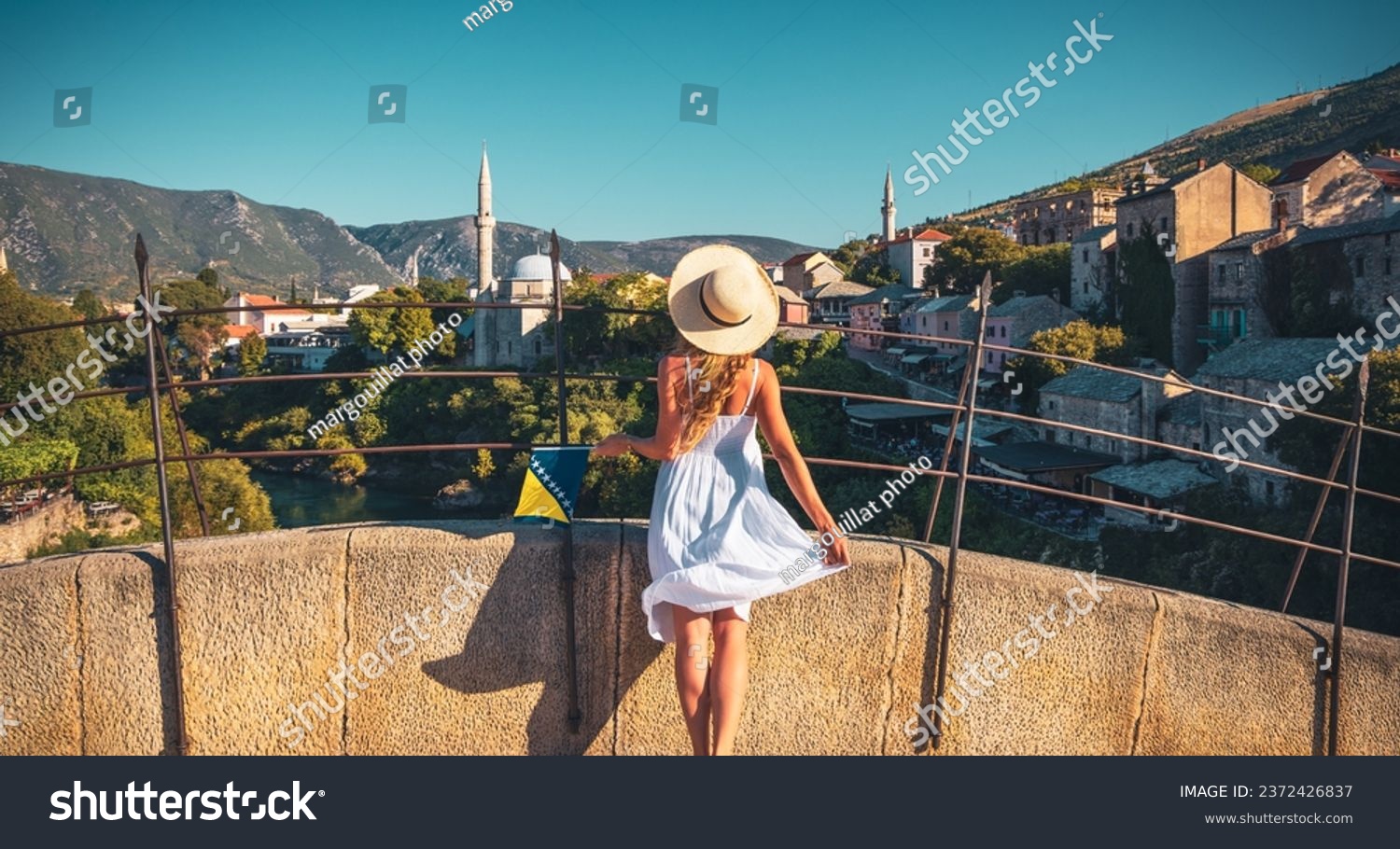 Woman in white dress looking at Old mosque in Town of Mostar- Bosnia Herzegovina #2372426837