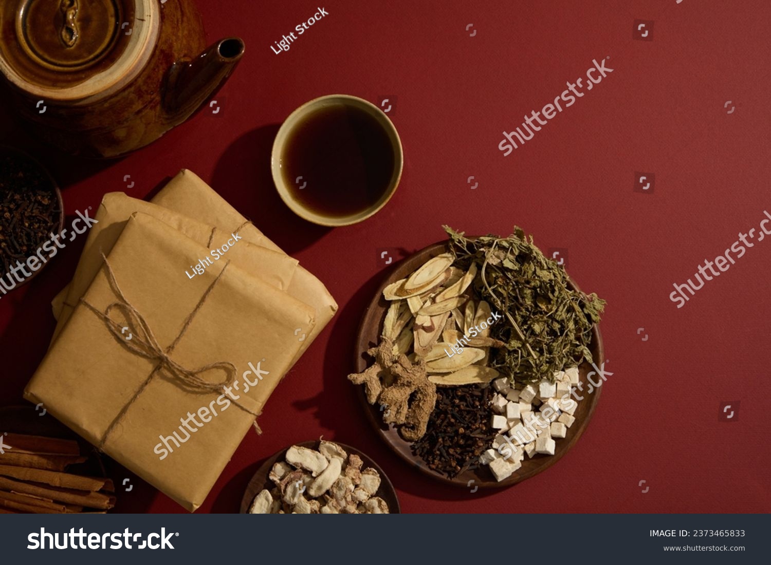 A bowl filled with tonic arranged with an earthen pot, packs of medicine and some wooden dishes containing several types of traditional Chinese medicine. Copy space. Blank space for mockup #2373465833