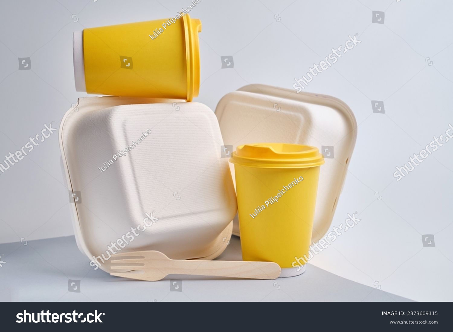Kraft paper tableware: cups, food boxes, wooden forks isolated on a light background. A set of various disposable tableware. Recycling and zero waste concept. Mock up  #2373609115