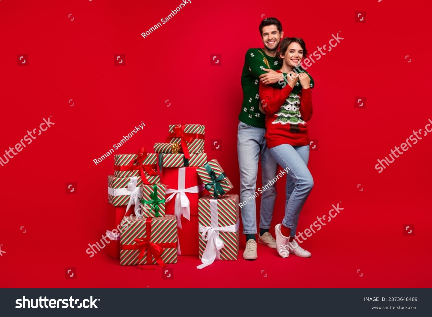 Full size photo of two peaceful idyllic partners cuddle pile stack newyear giftbox prepare party isolated on red color background #2373648489