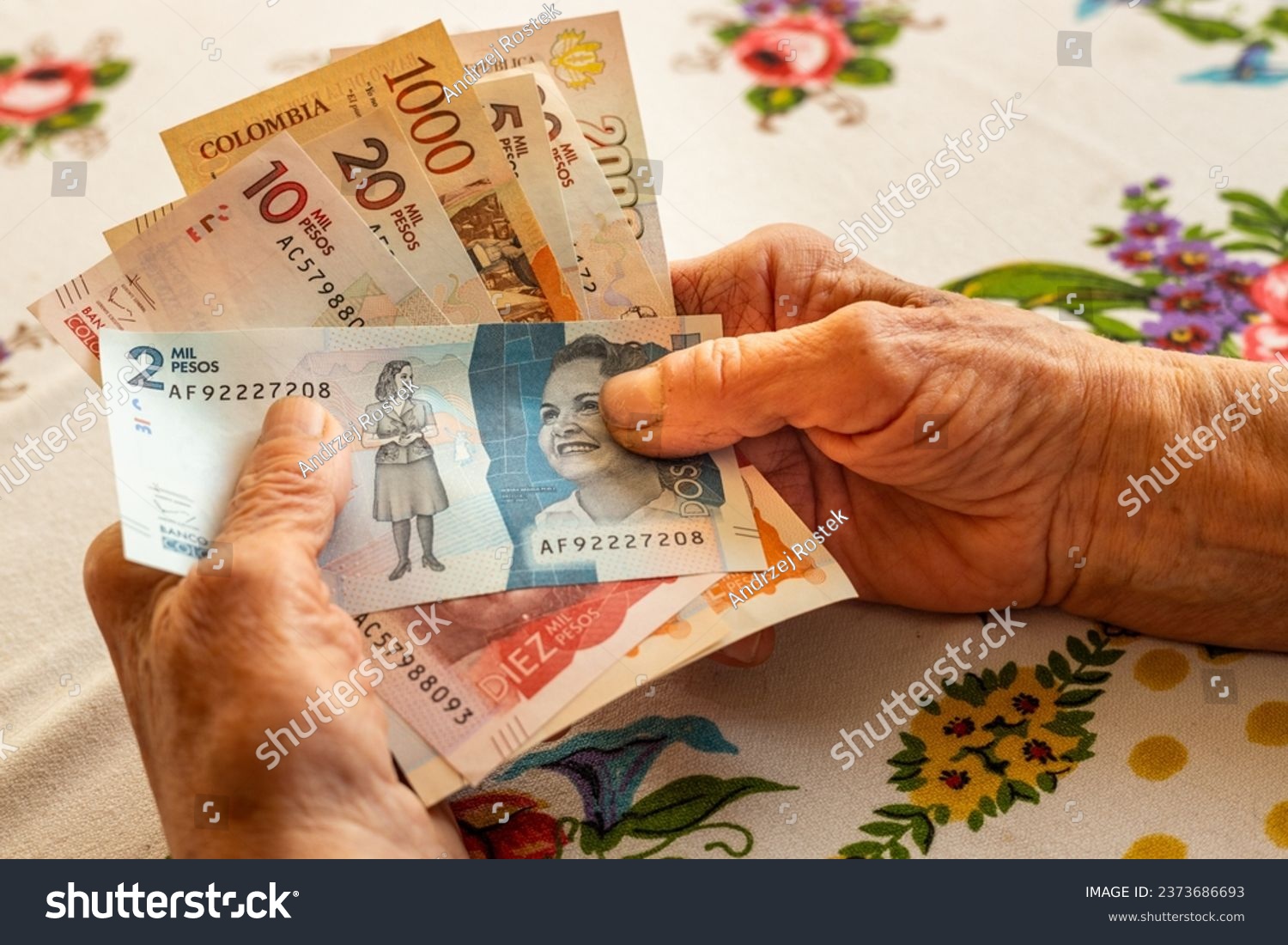 Colombian peso, a pensioner holds several banknotes in her hand, Financial problems of seniors, inflation and poverty in Colombia

 #2373686693