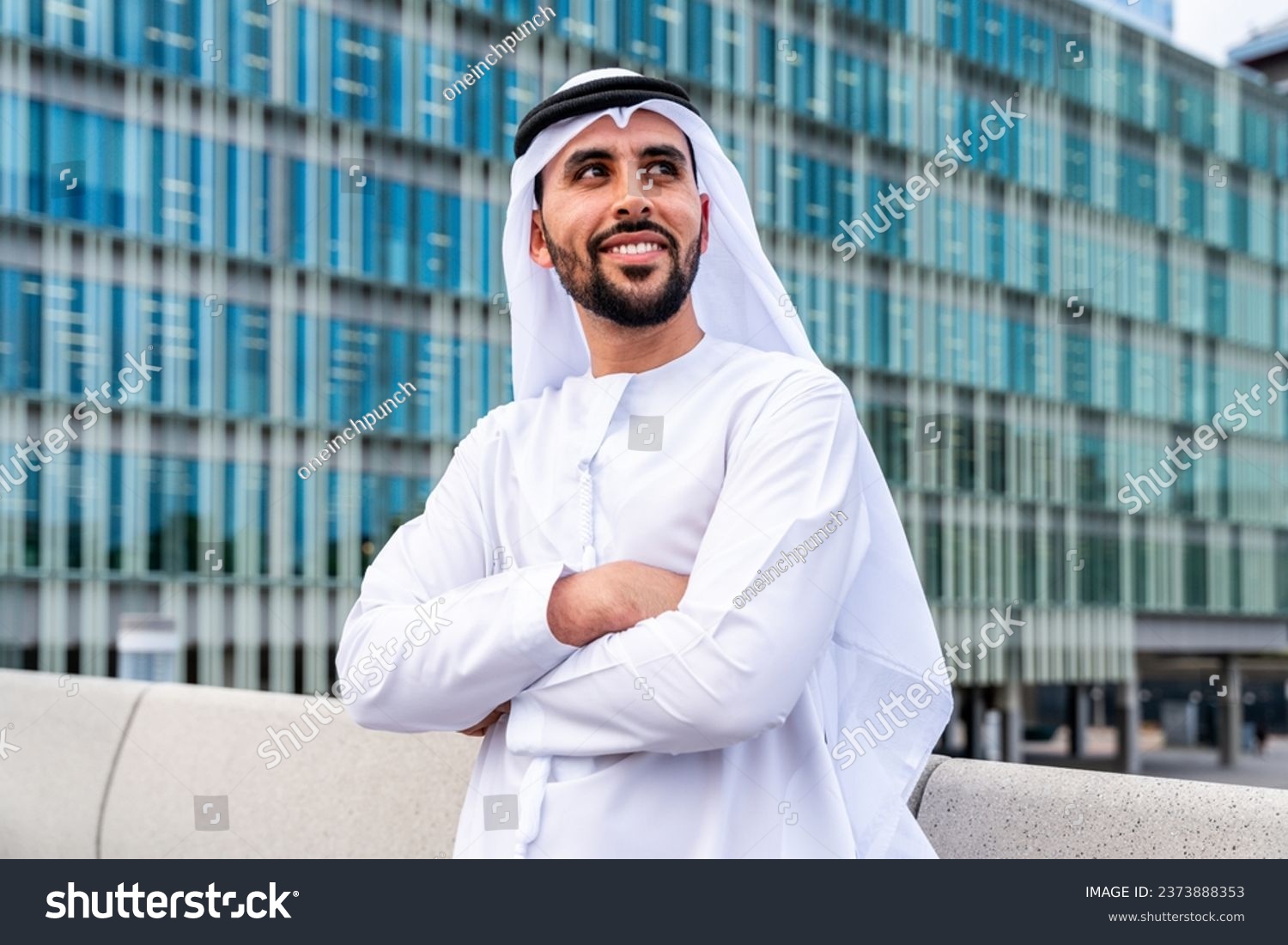 Arab middle-eastern man wearing emirati kandora traditional clothing in the city - Arabian muslim businessman strolling in urban business centre. #2373888353