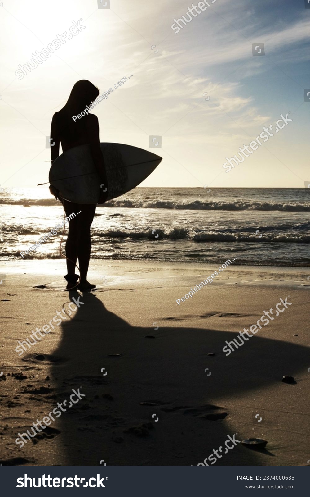 Silhouette, woman surfer on beach sand and ocean, exercise outdoor and healthy with surfboard and scenic sea view. Sports, shadow and sun with female person in nature and ready to surf for fitness #2374000635