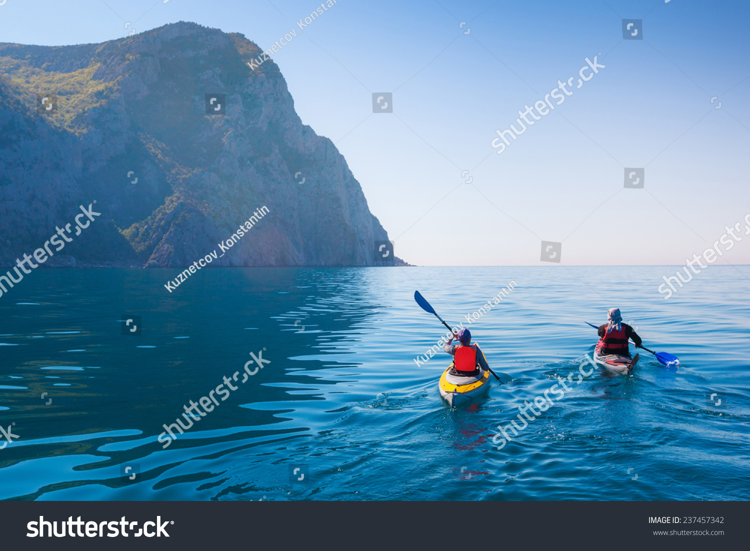 Kayaking in the sea from back view . #237457342