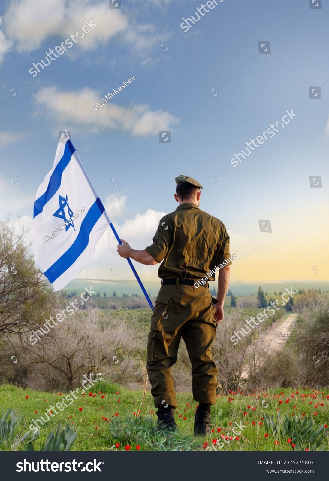 Israeli soldier with Israel flag against the sunset in the blooming desert. Concept - armed forces of Israel. #2375275807