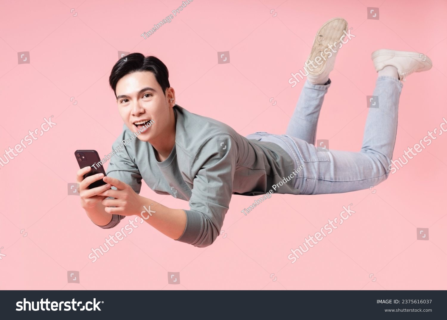 Photo of young Asian man flying on background #2375616037